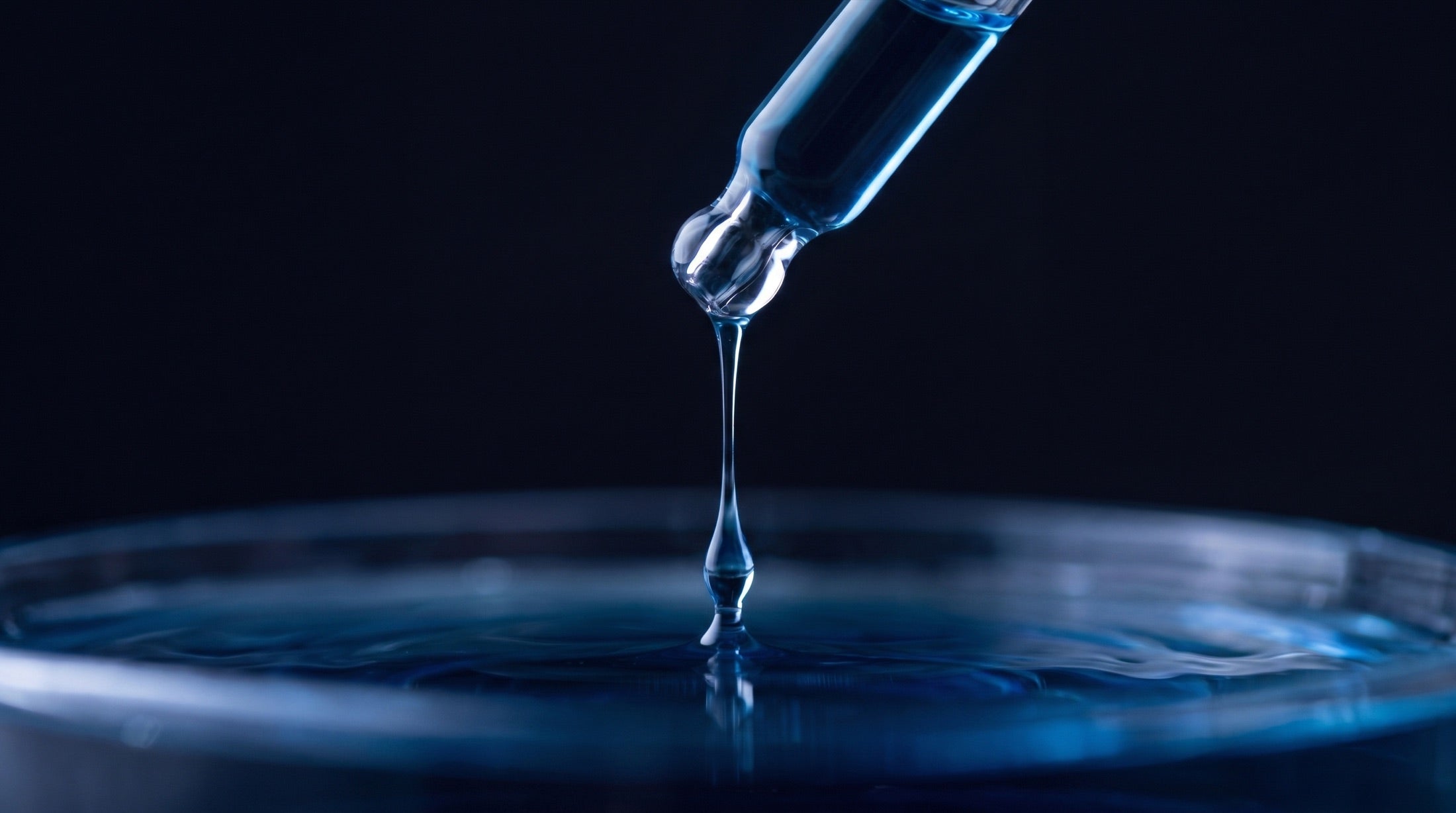 A drop of Skin³ serum falling into clear water